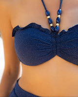 Navy blue bikini with beaded straps on a blurred background
