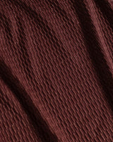 Close-up of brown fabric texture with metallic gold shimmer and jacquard