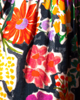 Close-up of a colorful floral fabric with vibrant flowers on a dark background