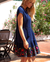 Woman wearing a blue dress with floral patterns on a patio