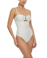 Woman wearing a white one-piece swimsuit with a bow detail on a white background