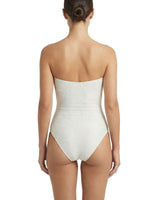 Woman wearing a strapless white swimsuit on a white background