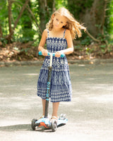 Young girl riding a scooter on a path in a forest