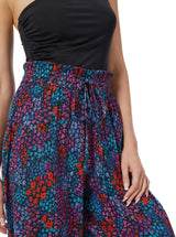 Close up shot of a model wearing a floral pattern organic cotton beach pants  with elastic waistband with drawstring and tassel detail