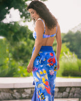 Woman wearing a colorful dress with a blurred green outdoor background