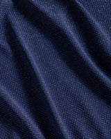 Close-up of dark blue fabric with subtle metallic shimmer and visible pique texture