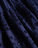 Close-up of dark blue eyelet and lace fabric with intricate cut-out patterns
