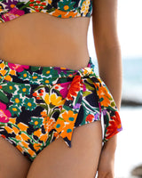 Colorful floral swimsuit with a blurred beach background