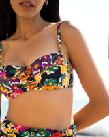 Woman wearing a colorful floral bikini with a blurred background