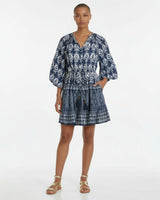 Woman wearing a blue patterned dress on a white background