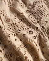 Close-up of beige lace fabric with intricate patterns