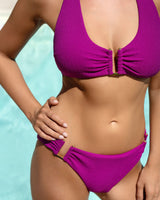 Person wearing a bright pink bikini against a light blue background