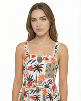 Woman wearing a colorful floral dress with palm tree design on a white background