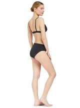 the side of model wearing a black classic bikini top with adjustable straps and a gold clasp with matching classic midrise bikini bottom