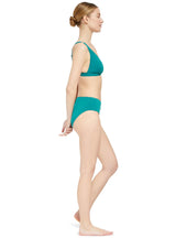 The side profile of a modelwearing a green plunge neckline, classic bikini topwith adjustable straps and an elastic underband with a matching classic midrise bikini bottom