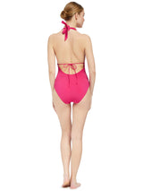 back of Model wearing fuchsia deep plunged one piece swimsuit with an adjustable halter-neck tie and under-bust string