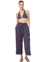 Model wearing a floral triangle bikini top with halter neck tie, adjustable cups, and a spaghetti tie under the bust with matching beach pants