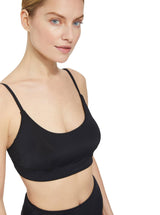 close up of a model wearing a black scoop neckline bikini top with under-bust band and adjustable straps with matching high rise bikini bottom