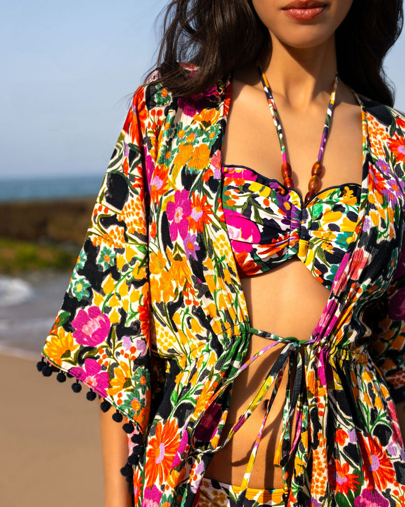 Woman wearing a colorful floral outfit on a beach
