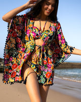 Woman in a colorful floral outfit on a beach