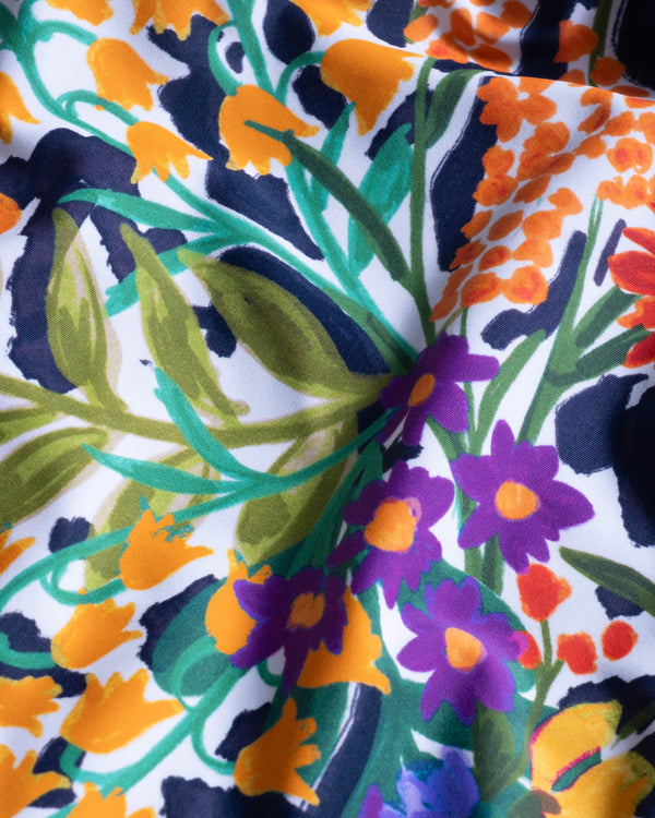 Close-up of a colorful floral fabric with orange, purple, green, and blue patterns.