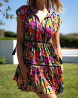 Person wearing a colorful floral dress outdoors on a sunny day