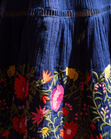 Close-up of a blue fabric with colorful floral embroidery