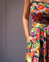 Colorful floral dress worn by a person against a neutral background