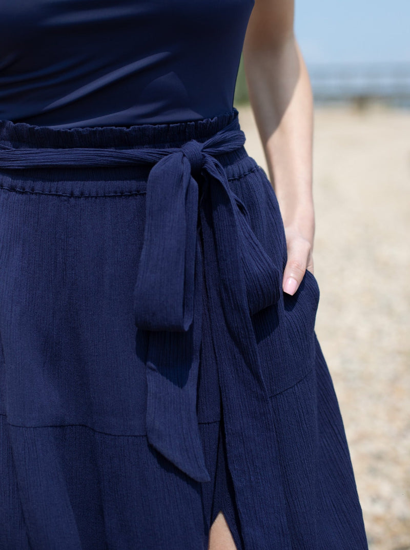 Very up close of model wearing long navy skirt