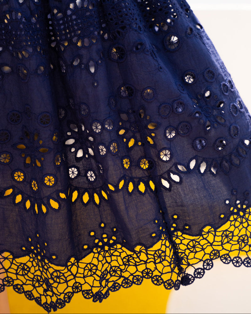 Navy blue skirt with intricate yellow and white lace details on a white background
