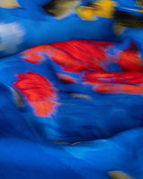 Close-up of a blue fabric with red and yellow abstract patterns