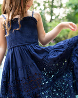 Navy blue dress with intricate detailing on a blurred natural background