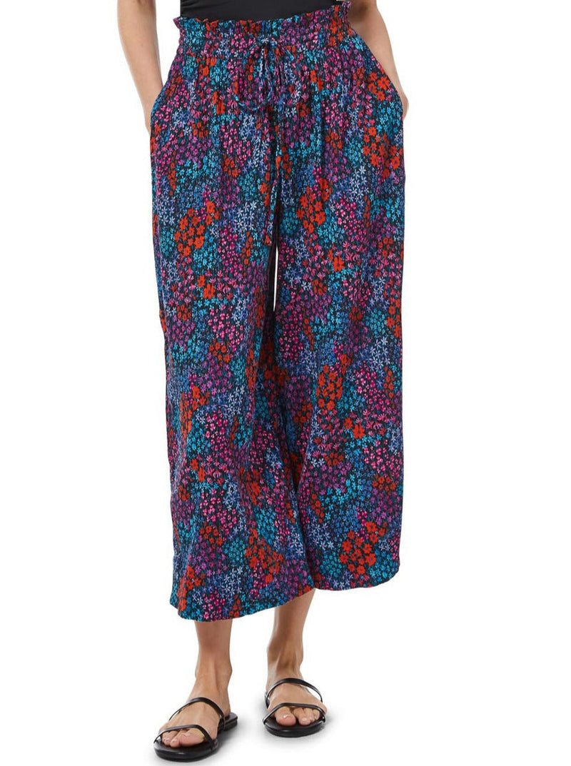 Close up shot of a model wearing a floral pattern organic cotton beach pants  with elastic waistband with drawstring and tassel detail