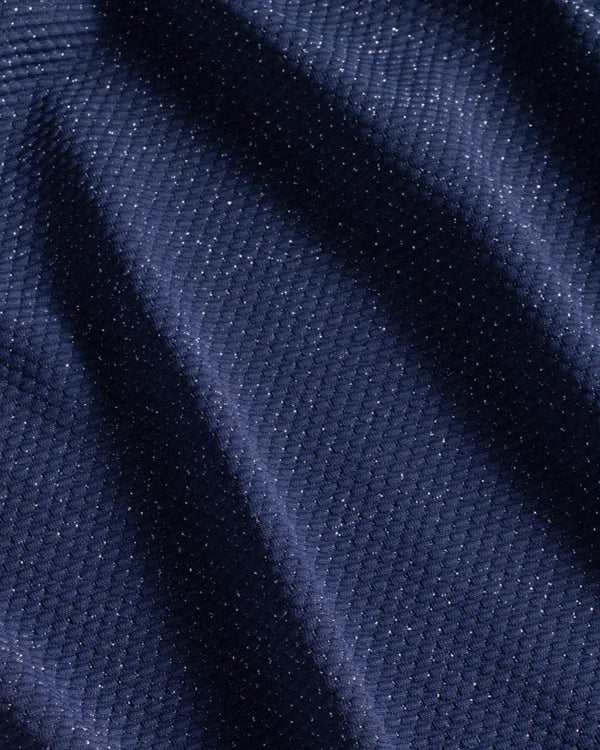 Close-up of dark blue fabric with subtle metallic shimmer and visible pique texture