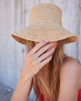 Person wearing a straw hat and red top with a blurred background