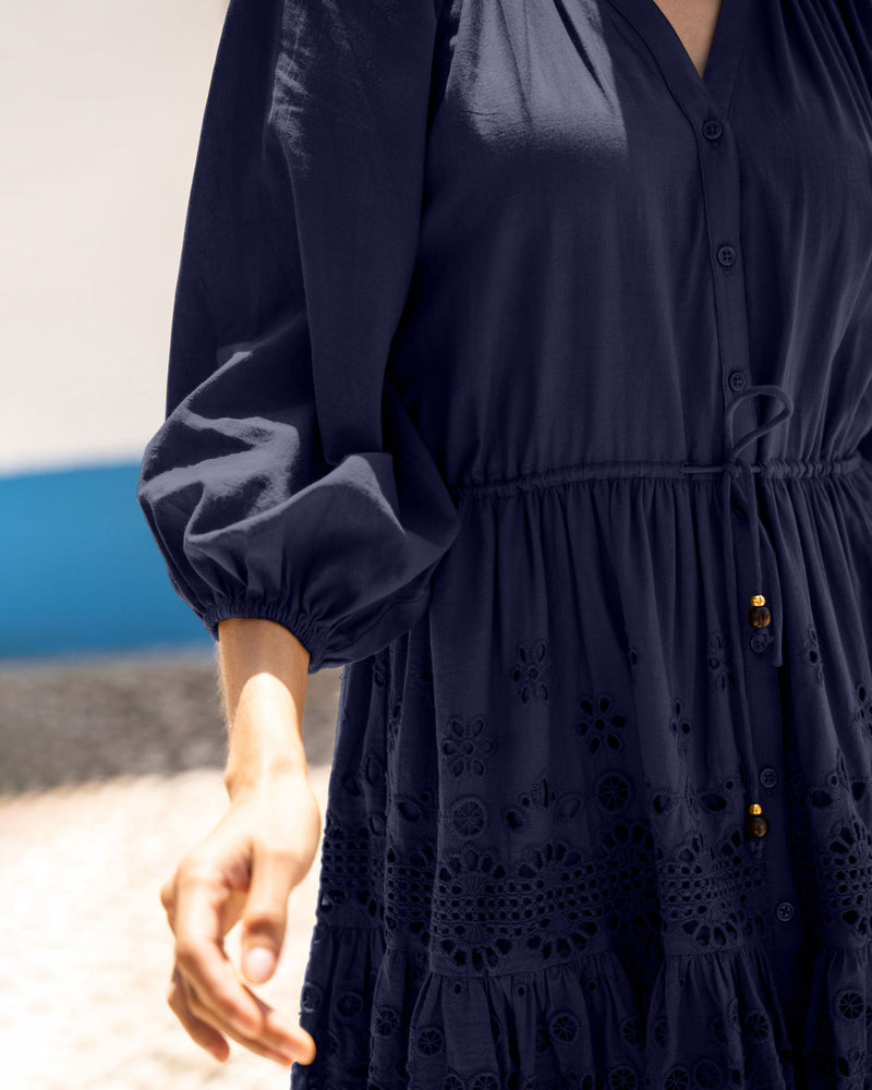 Navy blue dress with intricate detailing on a blurred background