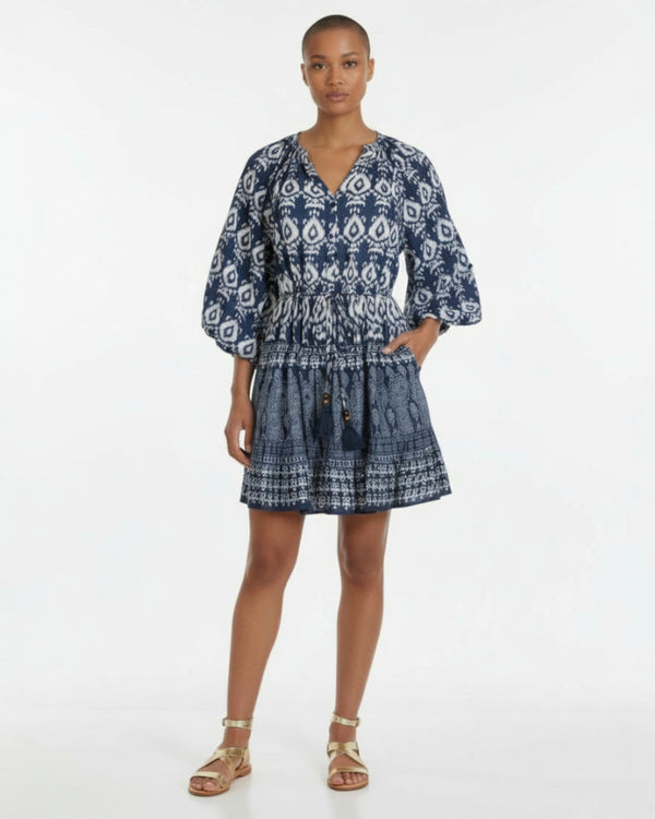 Woman wearing a blue patterned dress on a white background