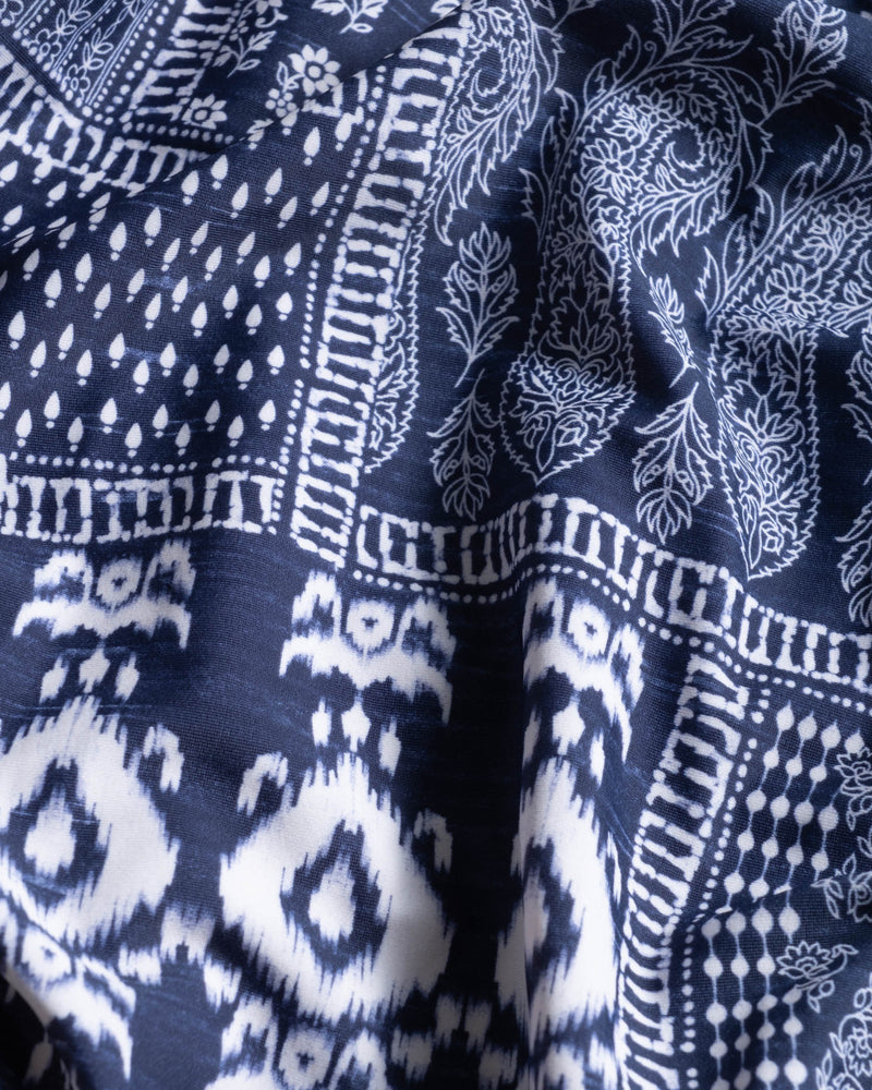 Close-up of blue fabric with white geometric and patchwork ikat patterns