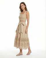 Woman wearing a beige lace dress with a white background