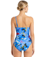 Woman wearing a colorful one-piece swimsuit on a white background