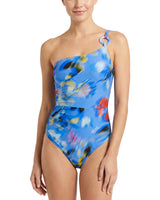 Woman wearing a blue floral one-piece swimsuit on a white background