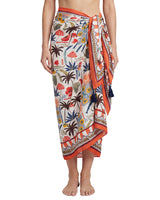 Person wearing a colorful floral and beach-themed sarong on a white background
