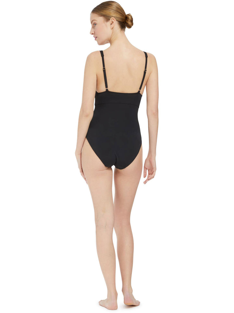 the back of a model wearing french cup black one piece swimsuit with a deep plunge-neckline, adjustable back straps, and shirring at the front waist with power compression mesh lining at the front lower torso