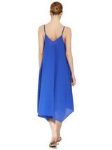 the back of a model wearing a cobalt blue strappy and long flowy dress with adjustable back shoulder straps, and v-neckline front and back with pockets