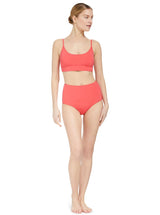 model wearing a coral scoop neckline bikini top with under-bust band and adjustable straps with matching high rise bikini bottom