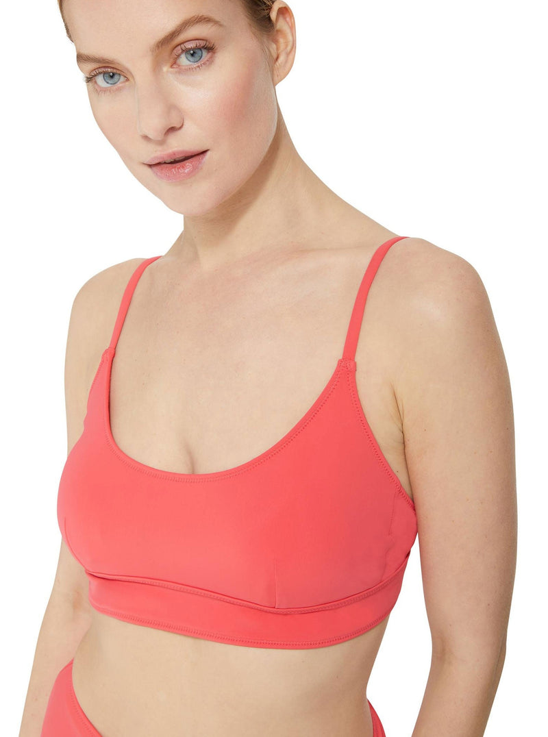 Close up of a model wearing a coral scoop neckline bikini top with under-bust band and adjustable straps with matching high rise bikini bottom 