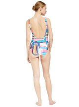 the back of a model wearing a geometric and graphic colored classic tank silhouette one piece swimsuit with lace-up front and deep open back