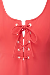 close up shot of a coral red classic tank silhouette one piece swimsuit with lace-up front 