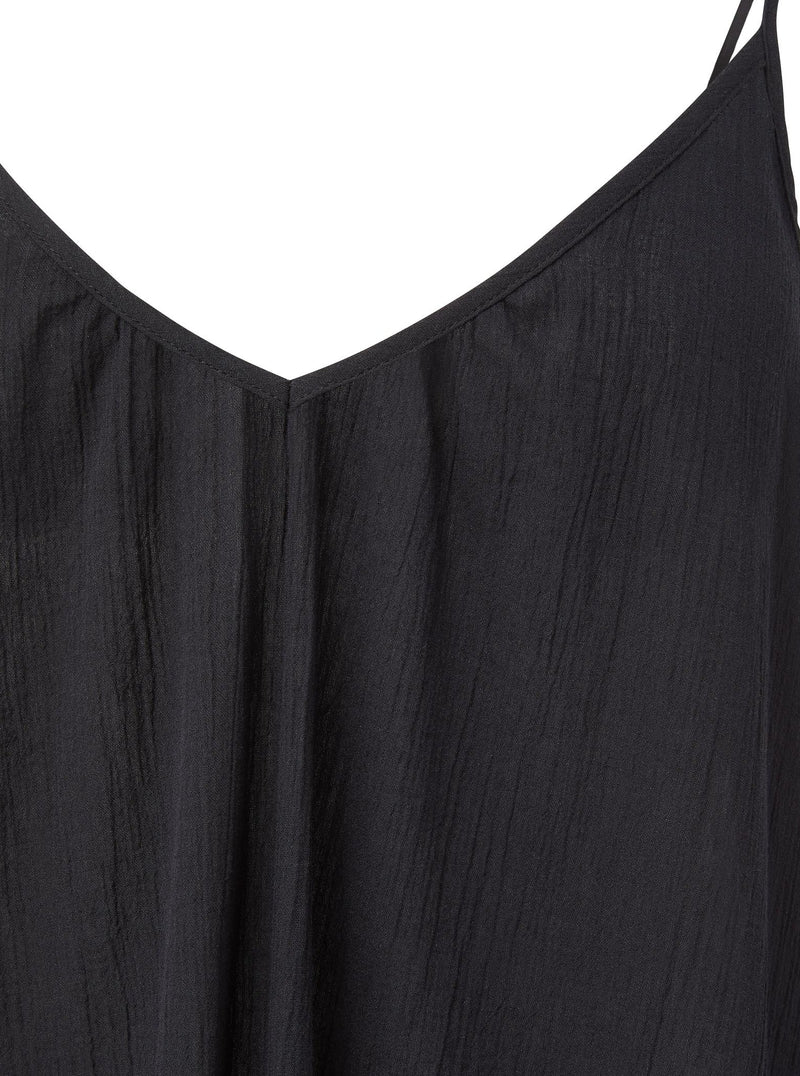 Close up and detailed shot of a black strappy dress with adjustable back shoulder straps, v-neckline front and back.