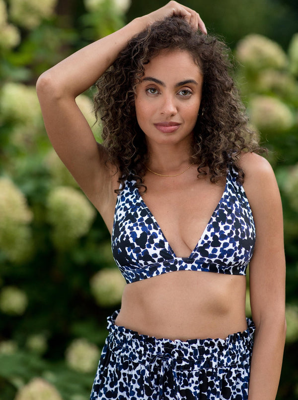 Model wearing a black and white leopard print plunge neckline, classic bikini top with adjustable straps and an elastic underband with a matching skirt